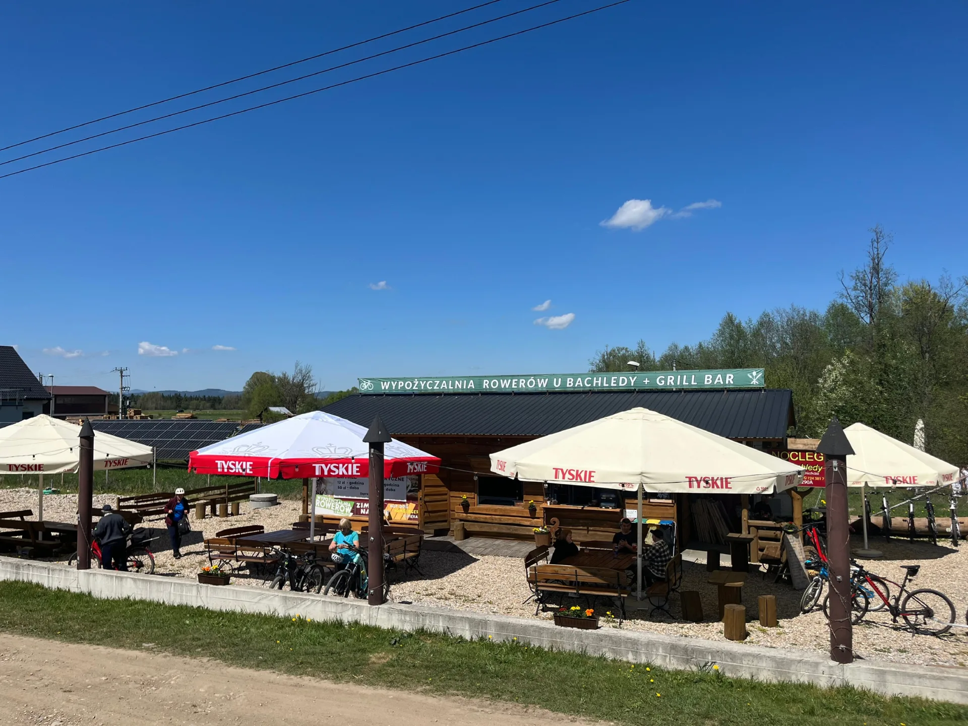 Front budynku wypożyczalni rowerów u Bachledy w Podczerwonem z szyldem grill bar