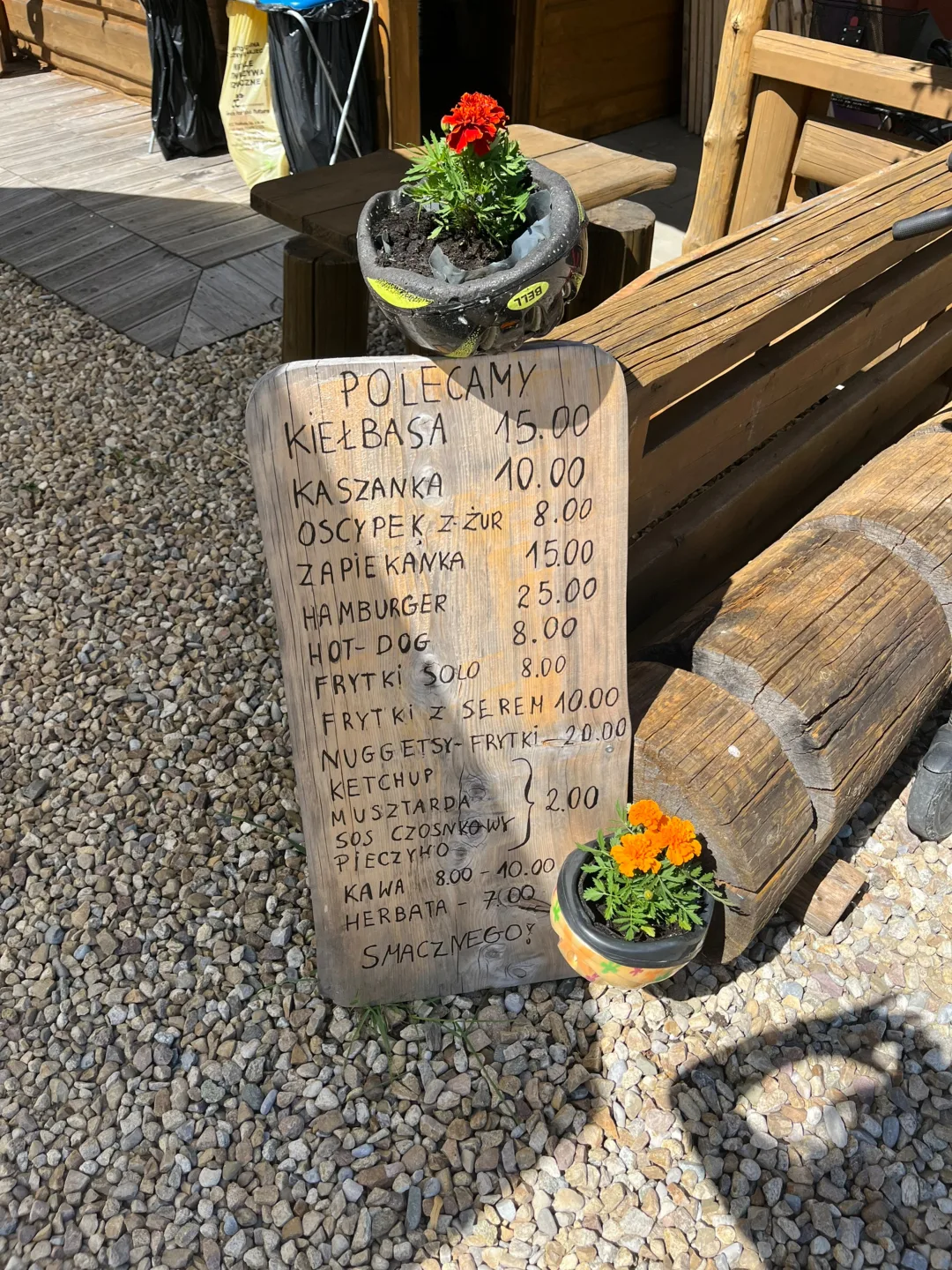 Drewniana tablica polecamy z cennikiem dań grillowych u Bachledy w Podczerwonem